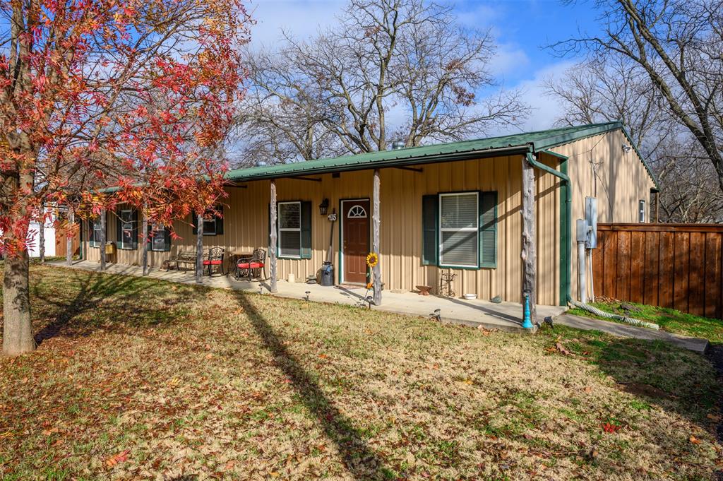 415 South Hill Street Pilot Point, TX 76258 - Photo 1 of 1 a view of a house with a large tree and wooden fence