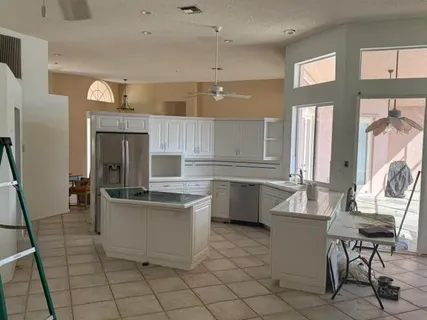 a kitchen with a sink and chairs