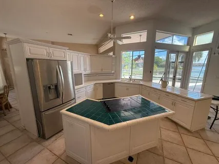 a kitchen with stainless steel appliances granite countertop a refrigerator a stove and a sink