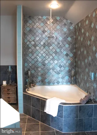 a bathroom with a tub a sink and a window