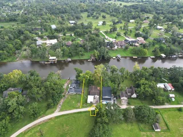 an aerial view of residential houses with outdoor space and lake view