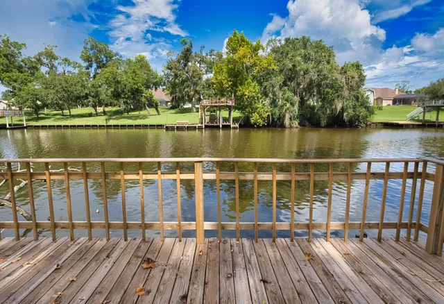 a view of a balcony with wooden floor and lake view