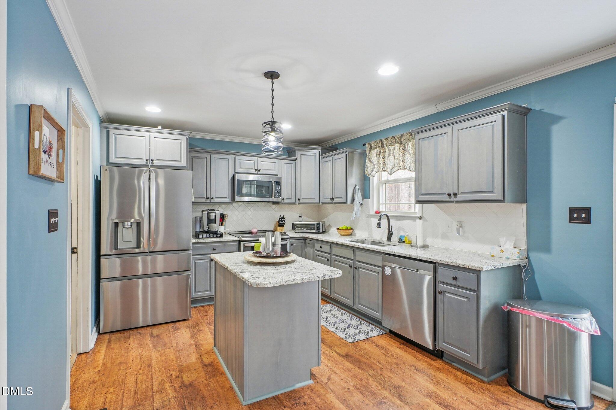 265 North Ridge Drive Louisburg, NC 27549 - Photo 14 of 33 a kitchen with a sink stainless steel appliances and cabinets