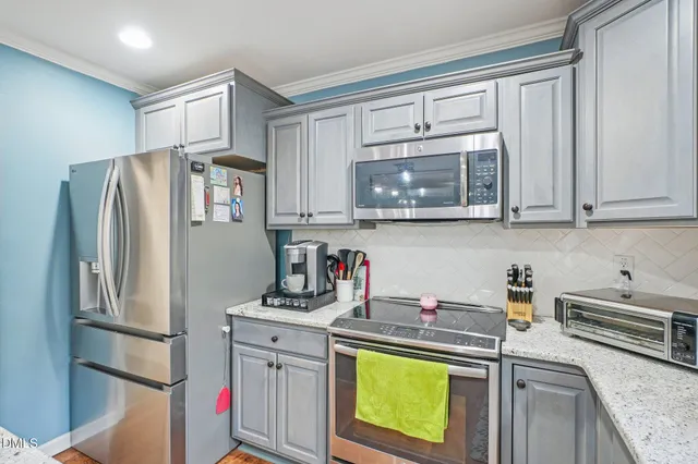 a kitchen with stainless steel appliances a refrigerator stove and microwave