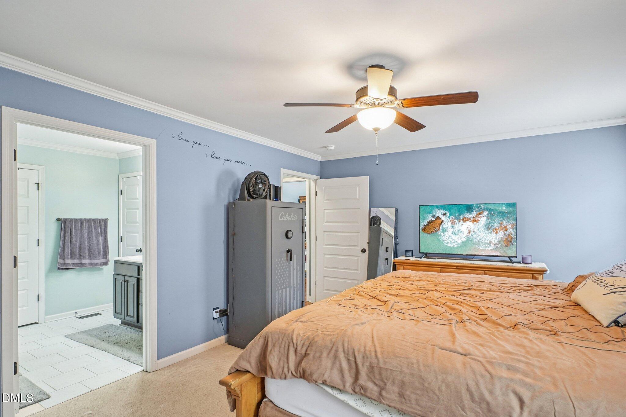 265 North Ridge Drive Louisburg, NC 27549 - Photo 20 of 33 a bedroom with a large bed and a chandelier