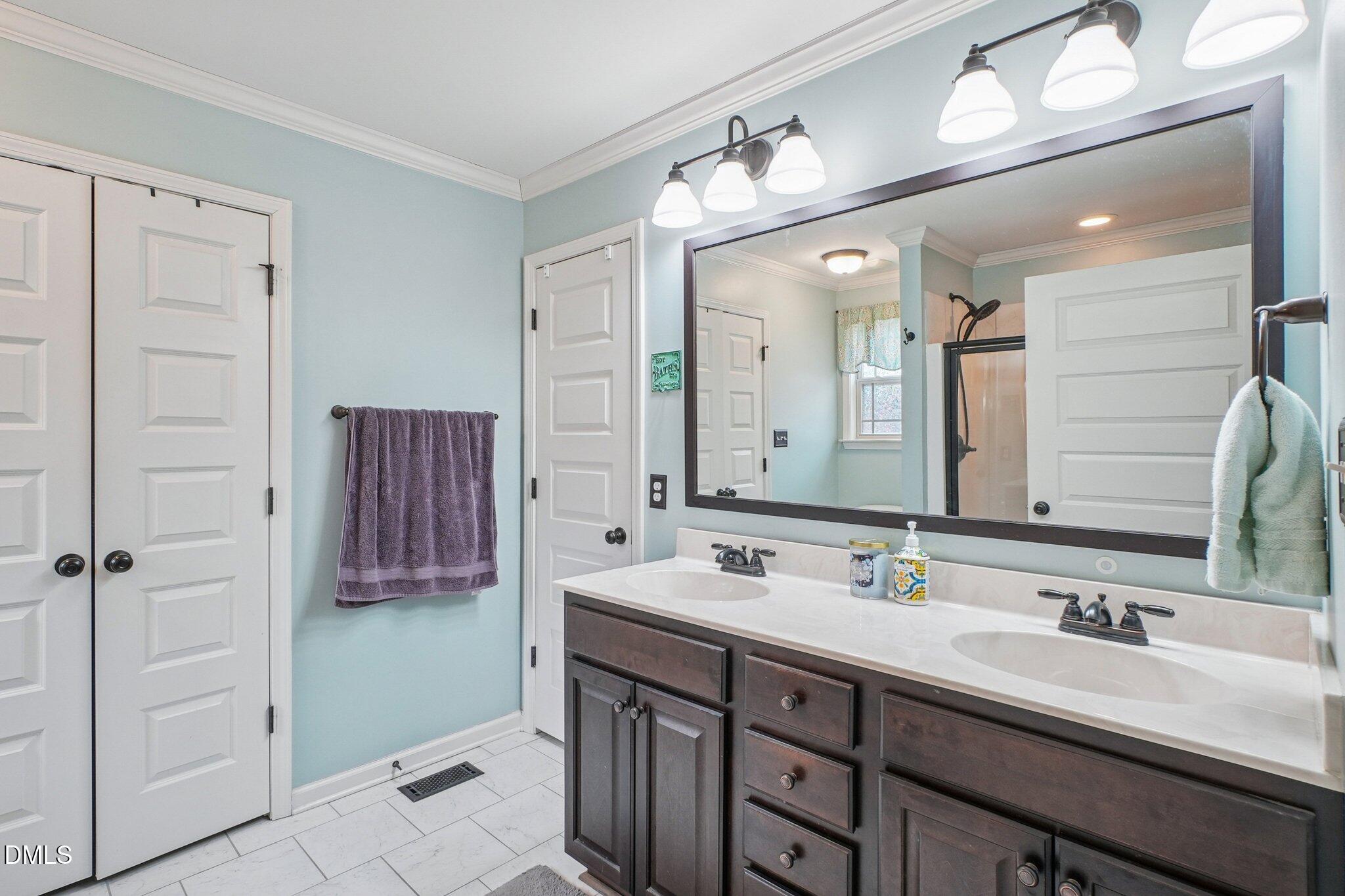 265 North Ridge Drive Louisburg, NC 27549 - Photo 22 of 33 a bathroom with a double vanity sink a and mirror