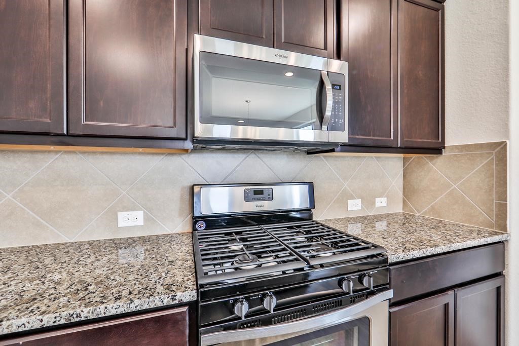 247 Sintra Lk Way Rosenberg, TX 77469 - Photo 11 of 28 a kitchen with granite countertop a stove and a sink