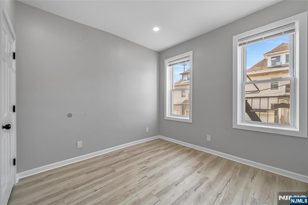 53 Henry Street, Unit D2 Passaic, NJ 07055 - Photo 3 of 12 a view of empty room with wooden floor and fan