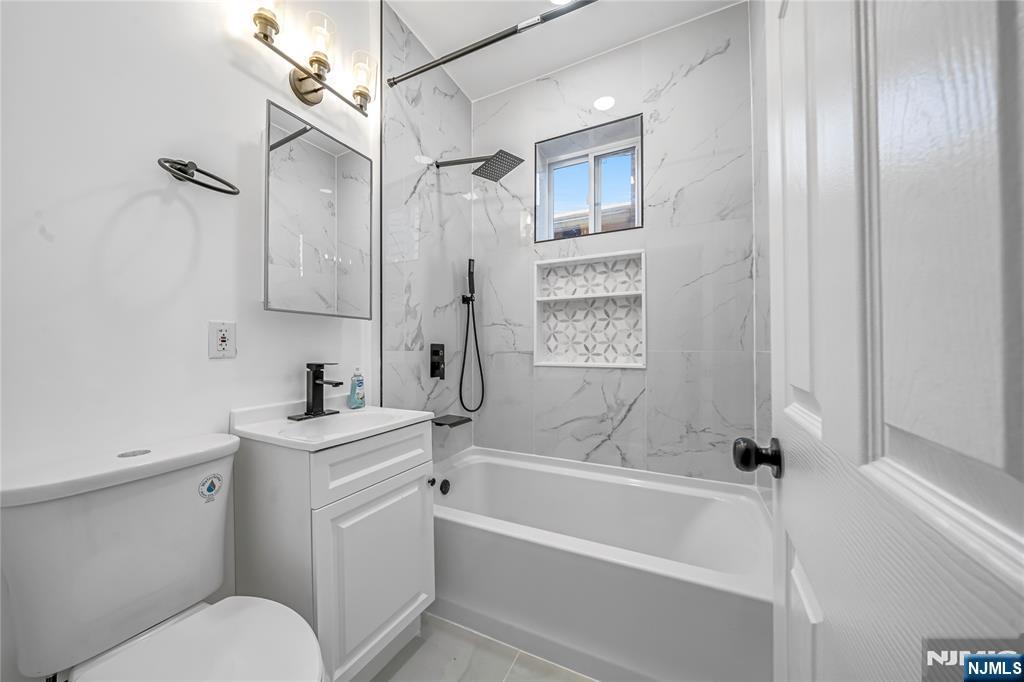 53 Henry Street, Unit D2 Passaic, NJ 07055 - Photo 4 of 12 a bathroom with a sink a toilet and shower