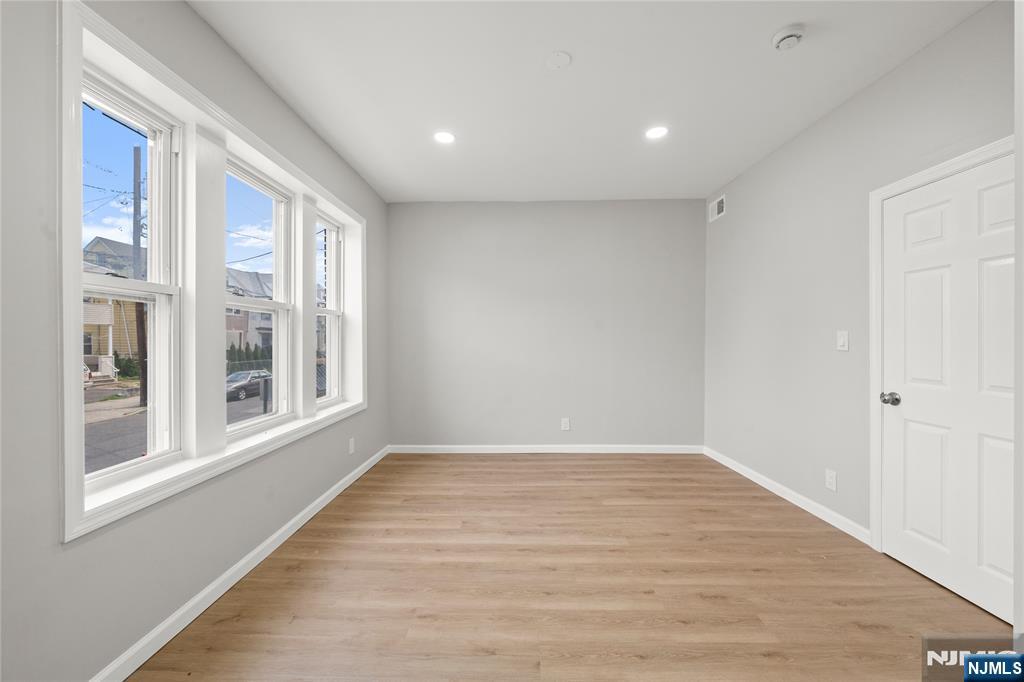 53 Henry Street, Unit D2 Passaic, NJ 07055 - Photo 10 of 12 a view of an empty room with wooden floor and a window