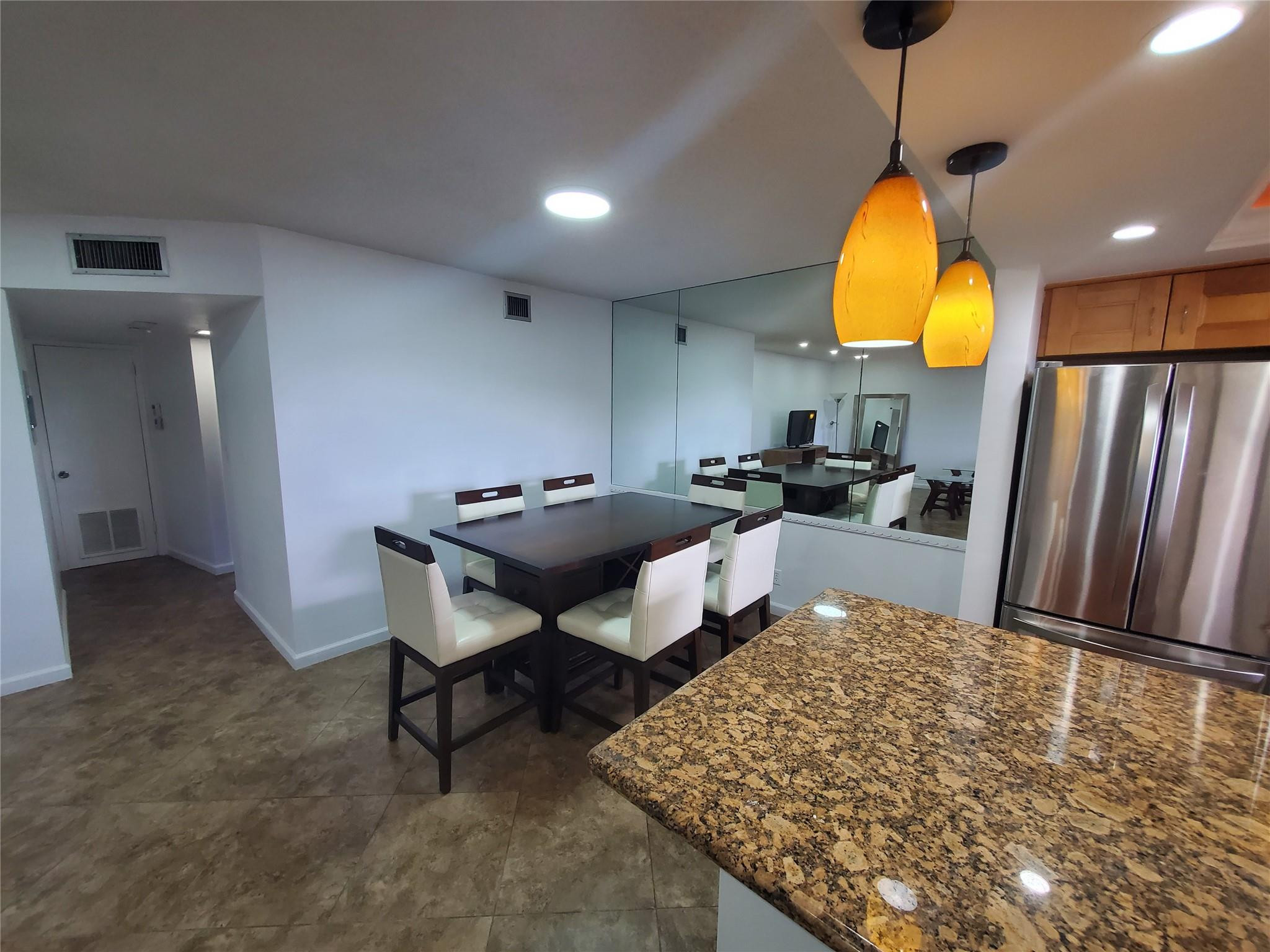 651 Pine Drive, Unit 305 Pompano Beach, FL 33060 - Photo 4 of 15 a living room with furniture a rug and kitchen chandelier