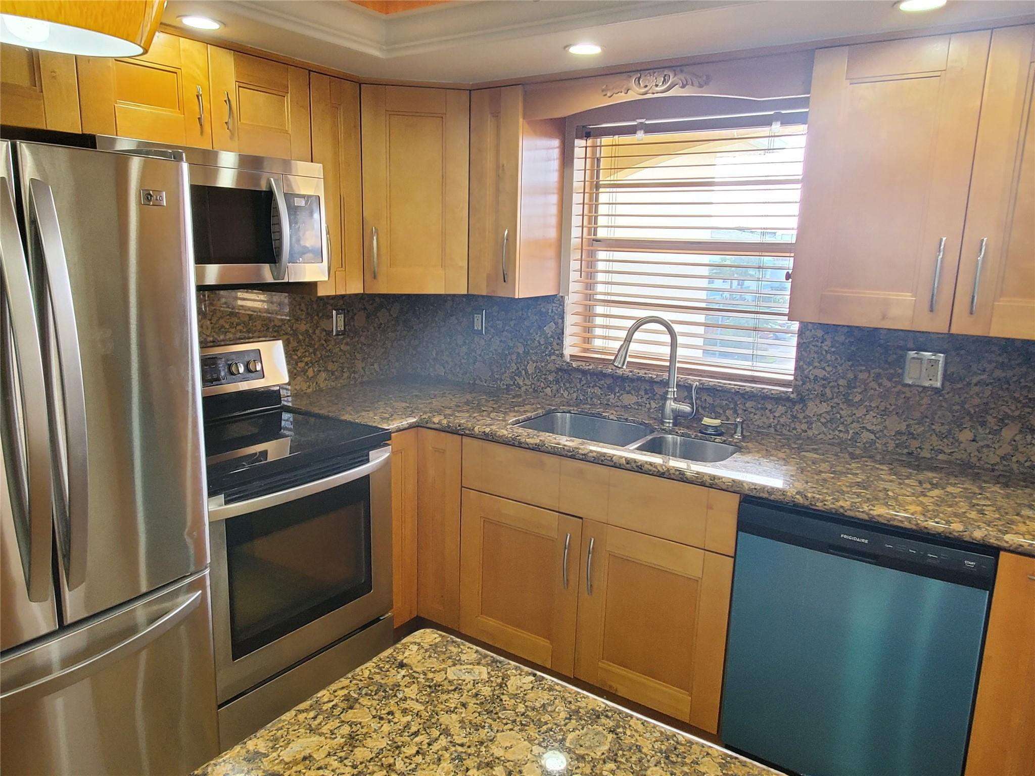 651 Pine Drive, Unit 305 Pompano Beach, FL 33060 - Photo 5 of 15 a kitchen with granite countertop stainless steel appliances a sink stove and refrigerator