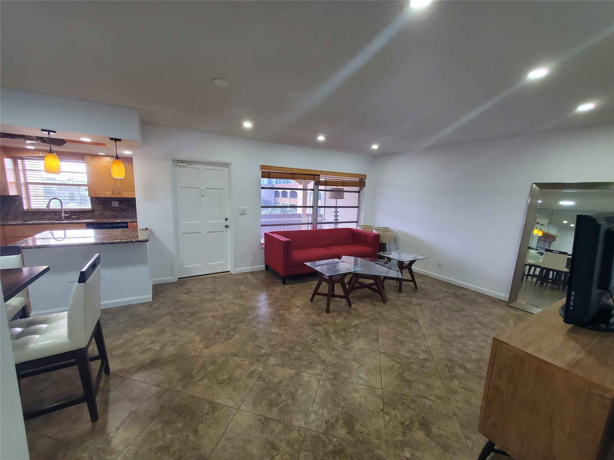 651 Pine Drive, Unit 305 Pompano Beach, FL 33060 - Photo 7 of 15 a living room with furniture and a flat screen tv