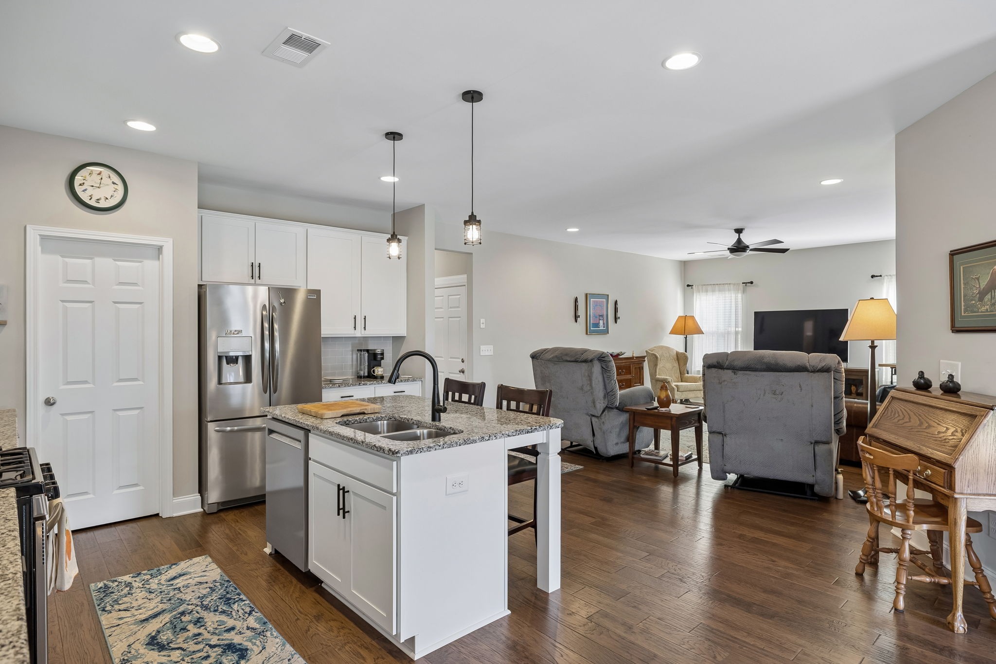 1017 Violet Street Spring Hill, TN 37174 - Photo 12 of 36 a kitchen with stainless steel appliances kitchen island granite countertop a refrigerator a stove a sink a dining table and chairs with wooden floor