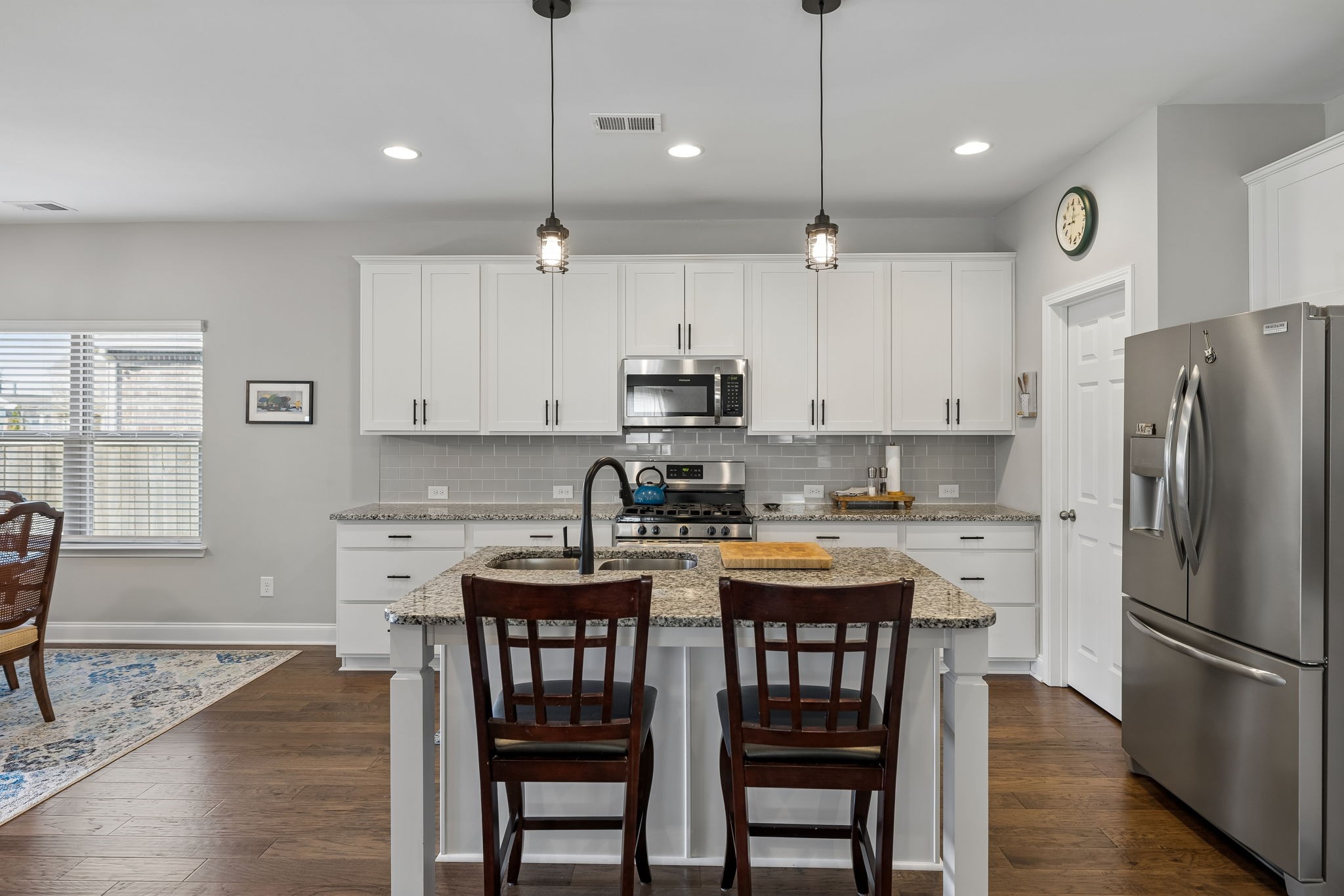1017 Violet Street Spring Hill, TN 37174 - Photo 9 of 36 a kitchen with stainless steel appliances granite countertop a dining table chairs refrigerator and microwave