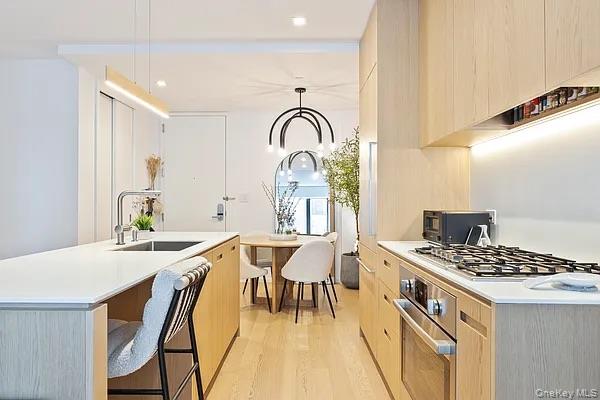 98 Front Street, Unit 9J Brooklyn, NY 11201 - Photo 2 of 10 Kitchen featuring light brown cabinets, modern cabinets, light wood-style flooring, pendant lighting, and recessed lighting
