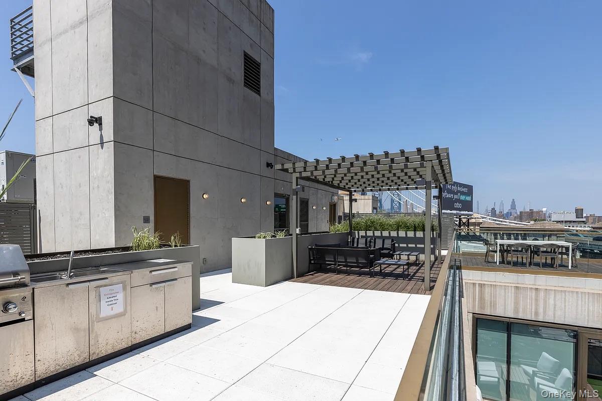 98 Front Street, Unit 9J Brooklyn, NY 11201 - Photo 9 of 10 View of patio with exterior kitchen, a pergola, and a city view