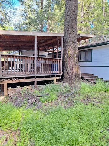 a view of a house with backyard and wooden fence