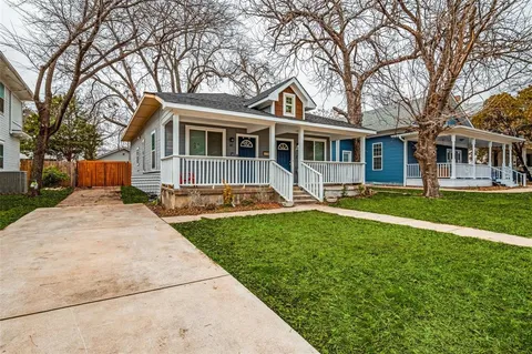a front view of a house with a garden and trees