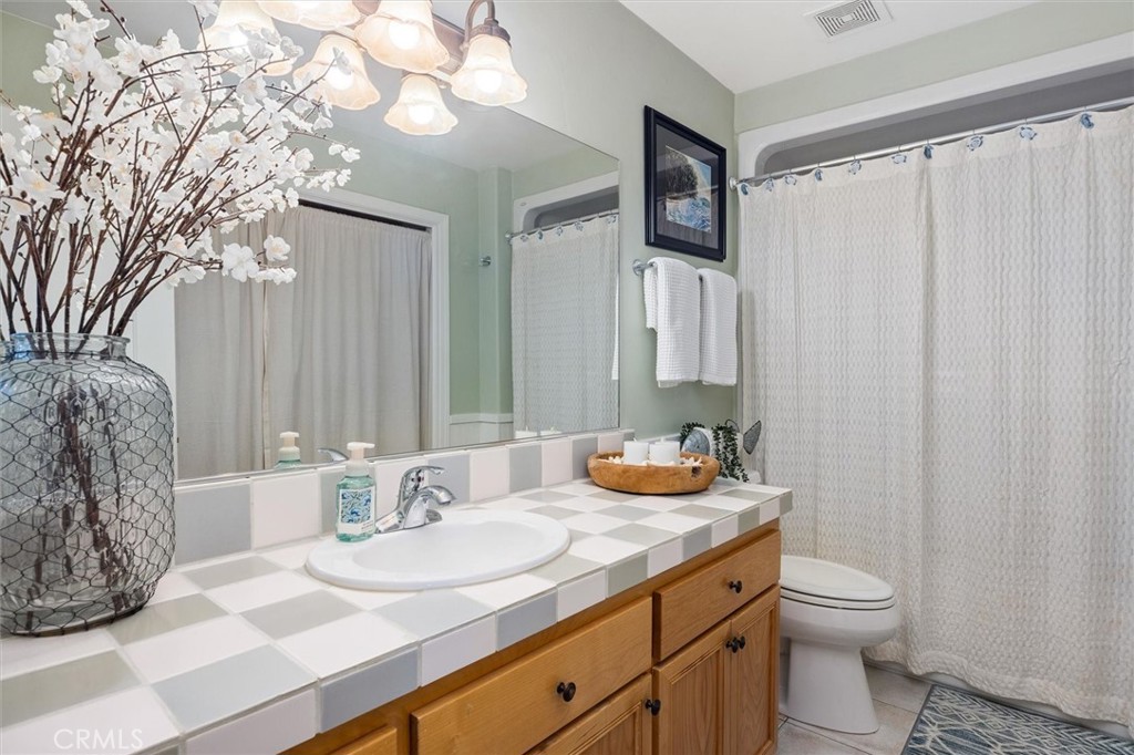 1187 Main Street Morro Bay, CA 93442 - Photo 15 of 33 a bathroom with a granite countertop sink and a toilet