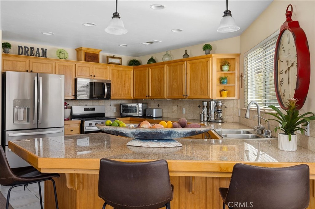 1187 Main Street Morro Bay, CA 93442 - Photo 7 of 33 a kitchen with stainless steel appliances granite countertop a sink a stove and a refrigerator