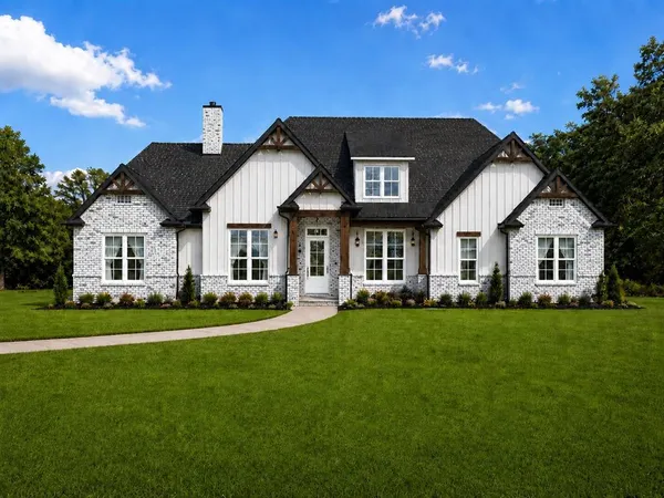 a front view of a house with a garden and porch