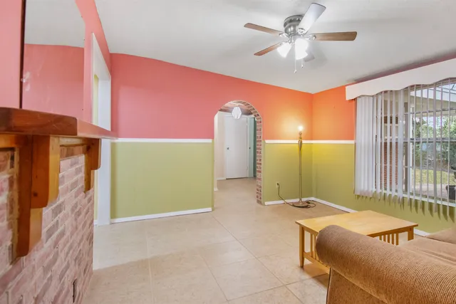 a living room with furniture and a ceiling fan
