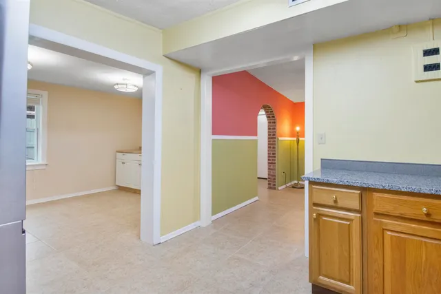 a kitchen with granite countertop a refrigerator and a stove top oven