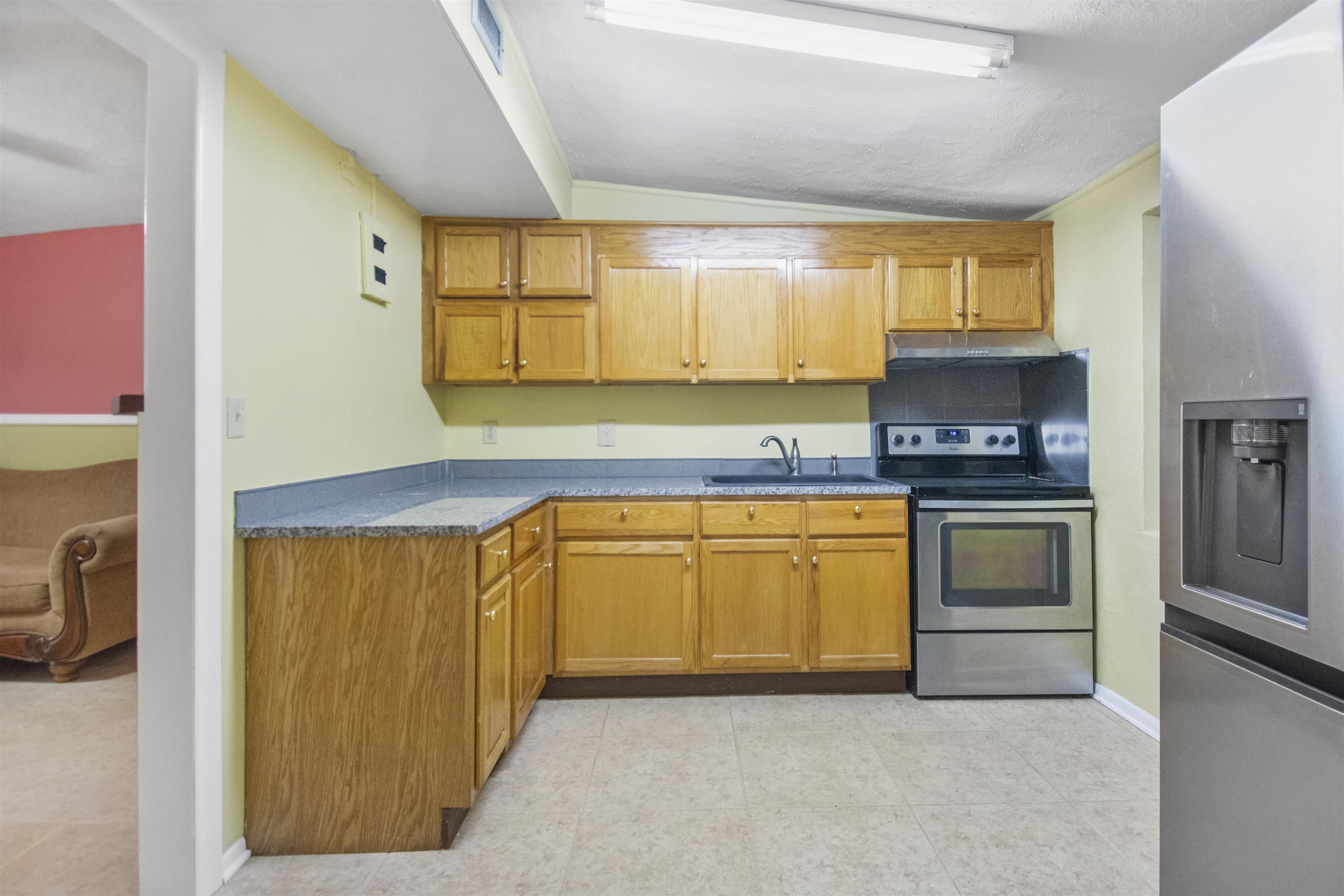 100 Spring Street St. Augustine, FL 32084 - Photo 9 of 21 a kitchen with granite countertop a refrigerator and a stove top oven
