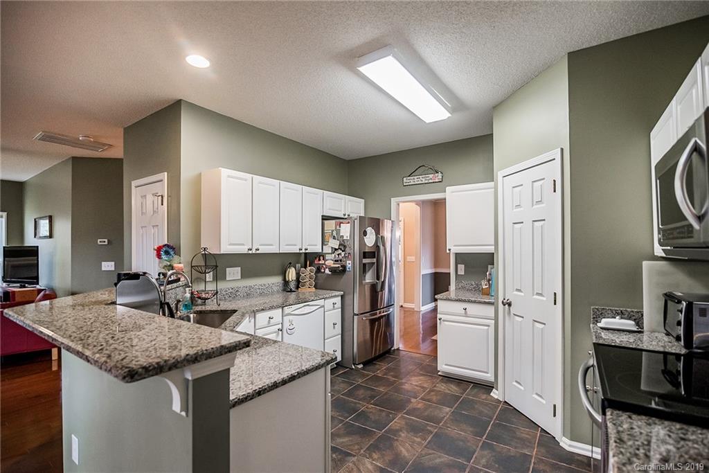 144 Comata Road Mooresville, NC 28117 - Photo 13 of 35 a kitchen with stainless steel appliances kitchen island granite countertop a sink and cabinets