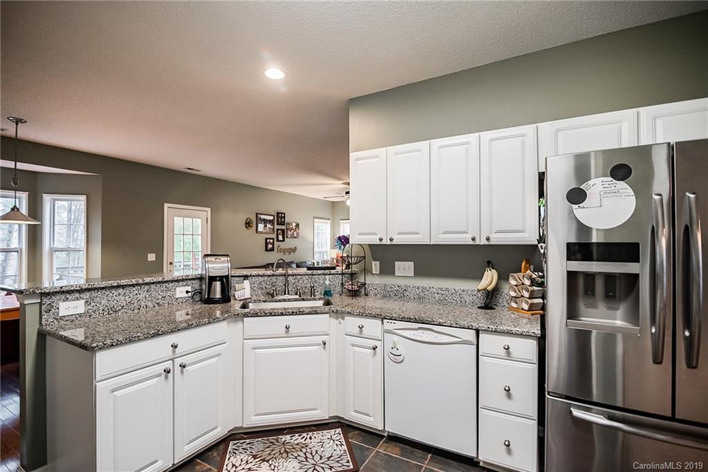 144 Comata Road Mooresville, NC 28117 - Photo 14 of 35 a kitchen with granite countertop stainless steel appliances a sink and cabinets