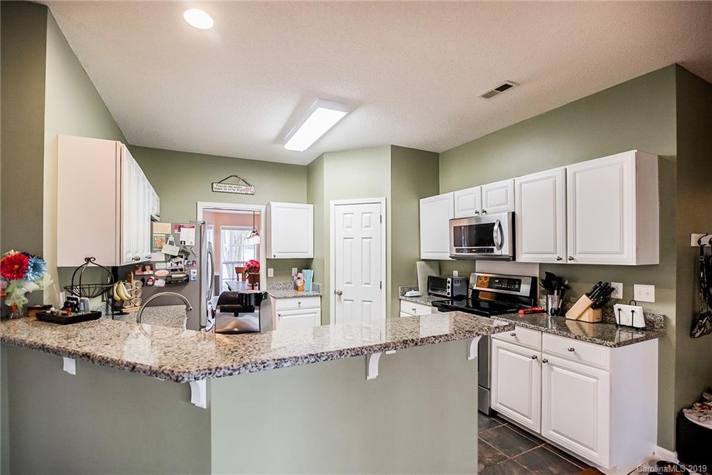 144 Comata Road Mooresville, NC 28117 - Photo 16 of 35 a kitchen with sink a stove and cabinets