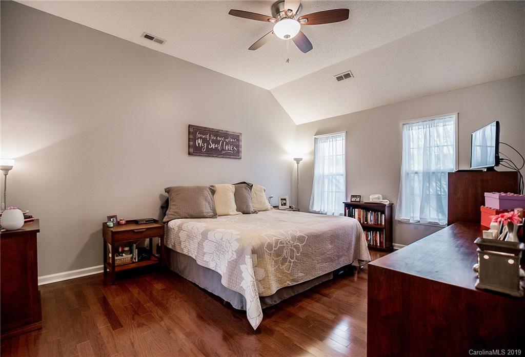 144 Comata Road Mooresville, NC 28117 - Photo 19 of 35 a bedroom with a bed and a chandelier