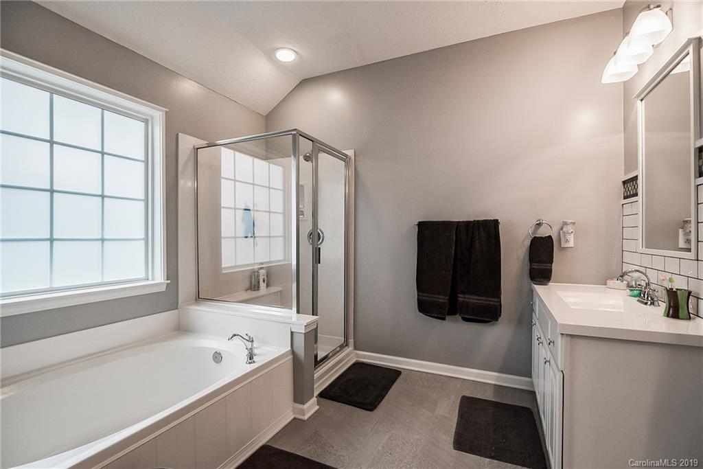 144 Comata Road Mooresville, NC 28117 - Photo 22 of 35 a bathroom with a tub a sink and a large mirror