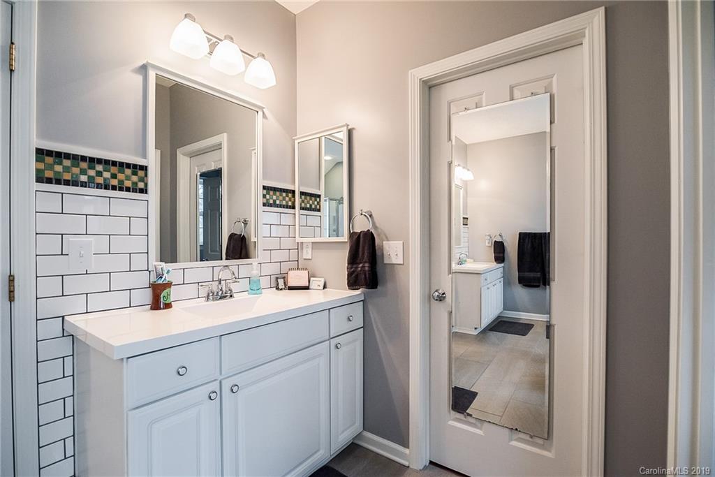144 Comata Road Mooresville, NC 28117 - Photo 23 of 35 a en suite bathroom with a double vanity sink a mirror and shower