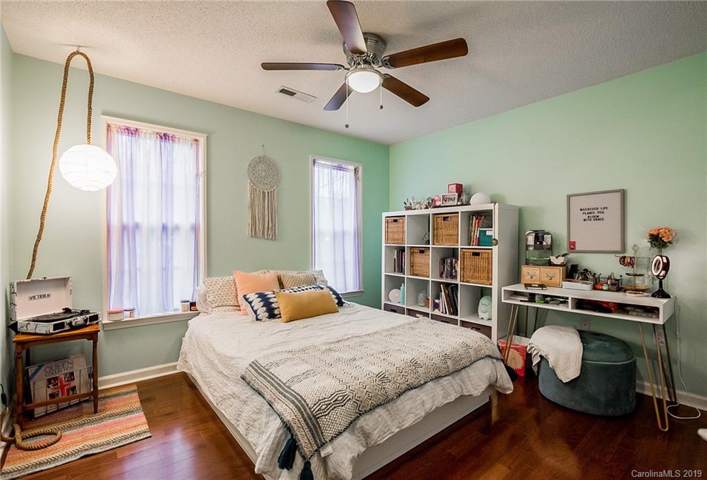 144 Comata Road Mooresville, NC 28117 - Photo 28 of 35 a bedroom with a bed and a chandelier
