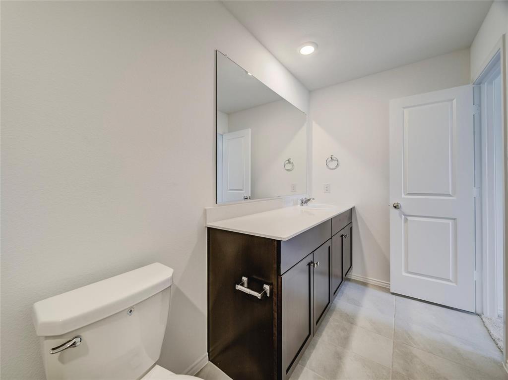 357 Sun Bluff Road Fort Worth, TX 76052 - Photo 16 of 35 Modern vanity featuring a light-toned countertop, integrated sink, and dark wood-finish cabinetry