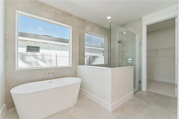 a bathroom with a bathtub and mirror