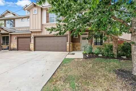 a front view of a house with a yard and trees