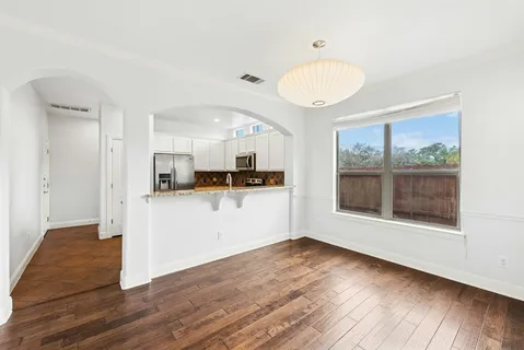 a view of empty room with wooden floor and window