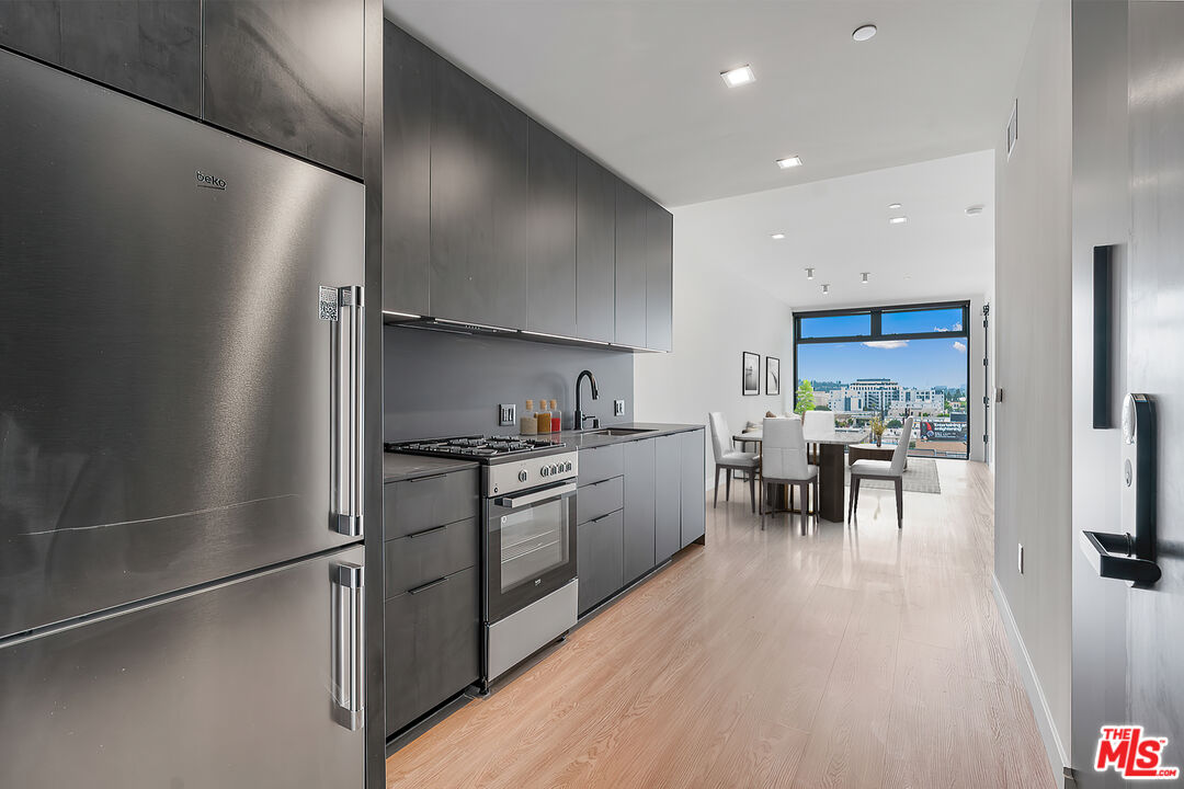 a kitchen with granite countertop stainless steel appliances a refrigerator and a stove top oven