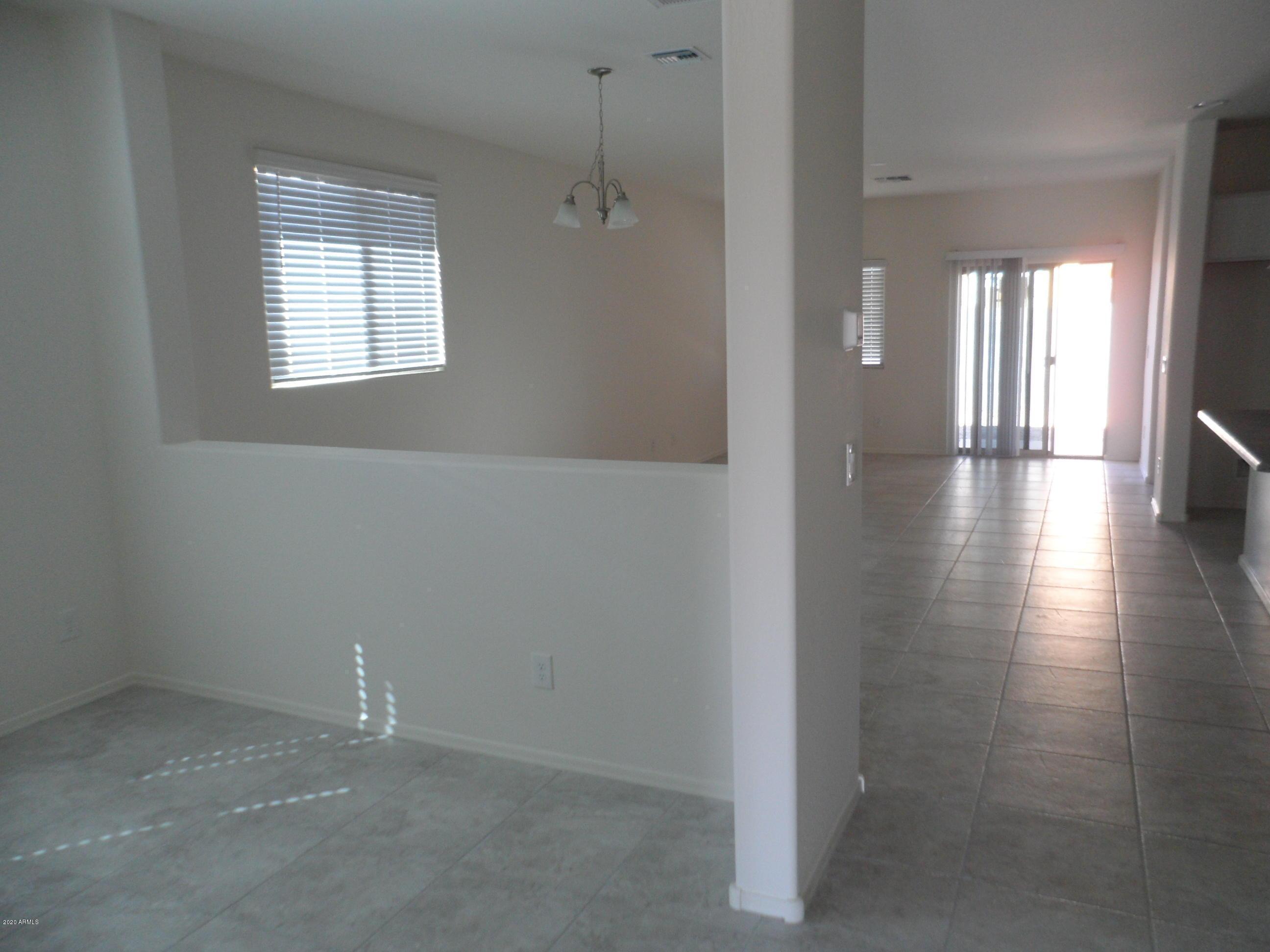 11618 West Boca Raton Road El Mirage, AZ 85335 - Photo 3 of 14 an empty room with wooden floor and windows