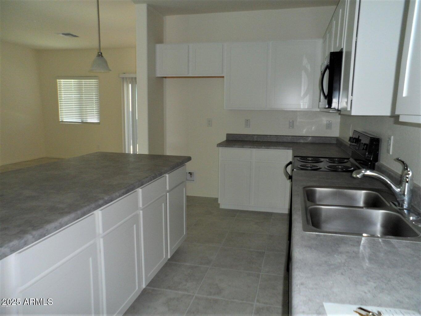 11618 West Boca Raton Road El Mirage, AZ 85335 - Photo 6 of 14 a kitchen with granite countertop a sink stove and cabinets