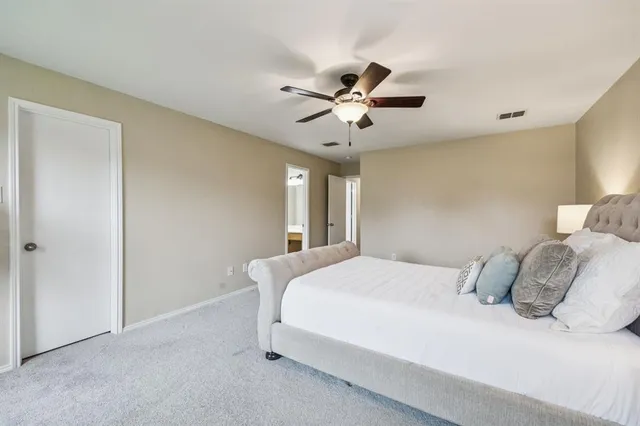 a bedroom with a large bed and a ceiling fan