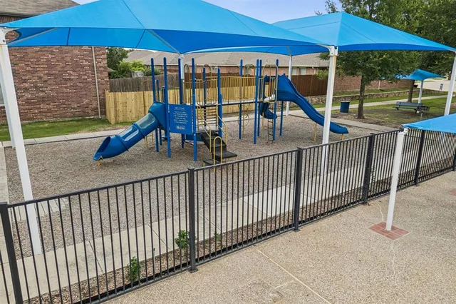 a view of a balcony with chairs and umbrella