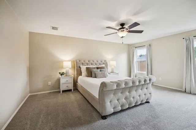 a bed room with a bed and a ceiling fan