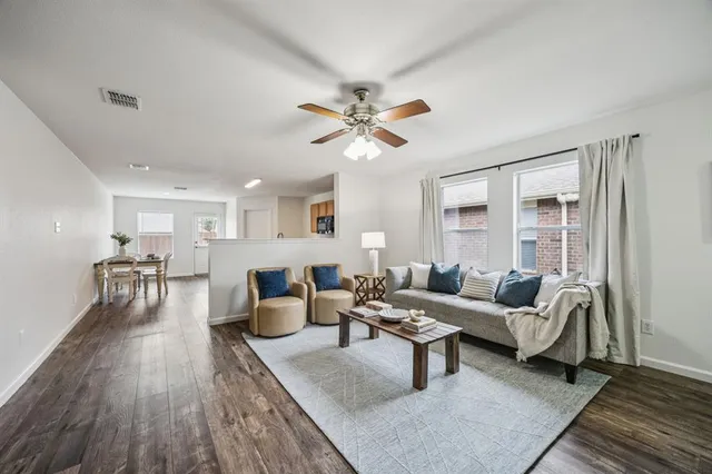 a living room with furniture and wooden floor