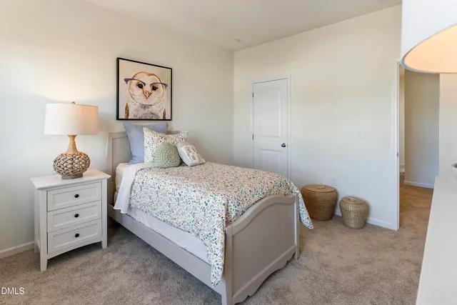 a bedroom with a bed and a lamp on dresser