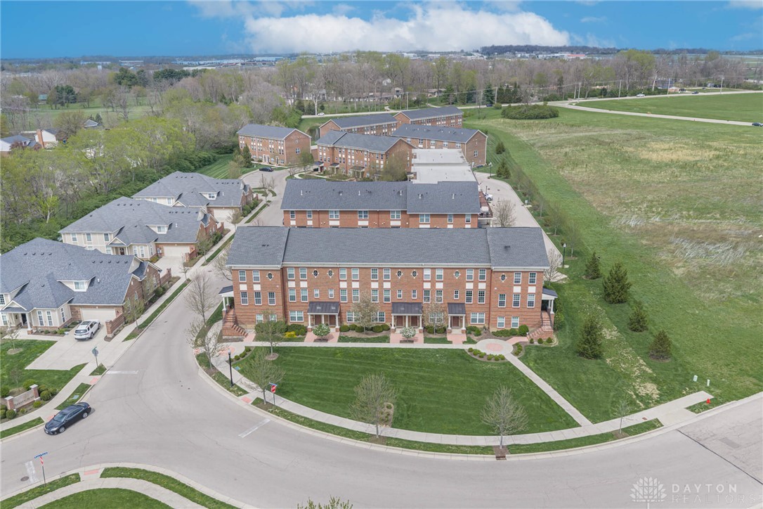 407 Brownstone Row Springboro, OH 45066 - Photo 54 of 54 This aerial perspective showcases a charming brick townhome community, nestled alongside lush green spaces.