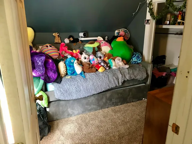 a bed sitting in a bedroom next to a window